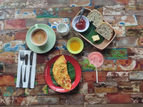 a table with a plate of food and a cup of coffee at Apalagi Villas in Gili Air