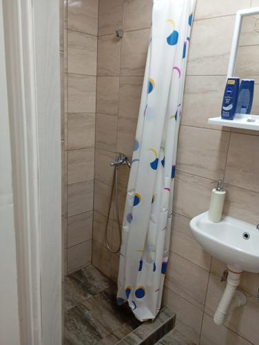 a bathroom with a shower curtain and a sink at Nataly Apartment in Belgrade