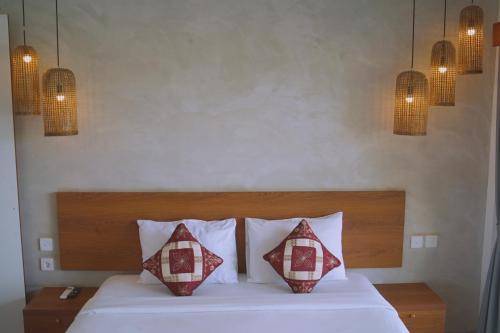 a bedroom with a bed with two pillows on it at The Kd Suites & Coffee Shop in Munggu
