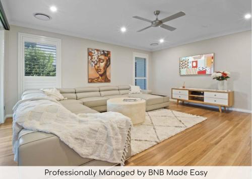a living room with a couch and a tv at Thane Retreat - Cosy Ambience, Modern Entertaining in Wagga Wagga