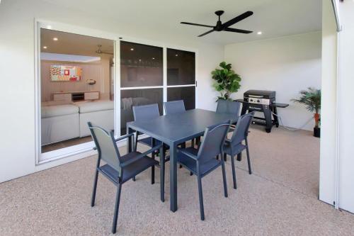 a dining room table with chairs and a ceiling fan at Thane Retreat - Cosy Ambience, Modern Entertaining in Wagga Wagga