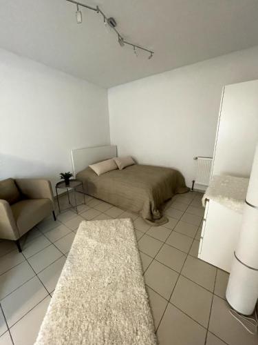 a bedroom with a bed and a chair and a couch at Altstadt-Apartment Bad Nauheim in Bad Nauheim