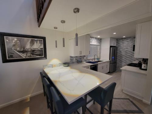a kitchen with a large white table and chairs at Luv Oceanside Views-1 House to Beach, Boardwalk and Waves-Spacious Rooftop Sun Deck-Plus King Beds too! in San Diego