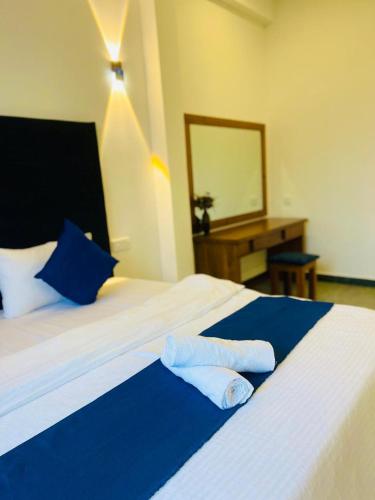 a bedroom with a large bed with two towels on it at Hanthana SK Paradise in Gampola