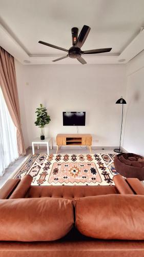 a living room with a couch and a ceiling fan at Cik B Homestay - Musliim Only in Batang Kali