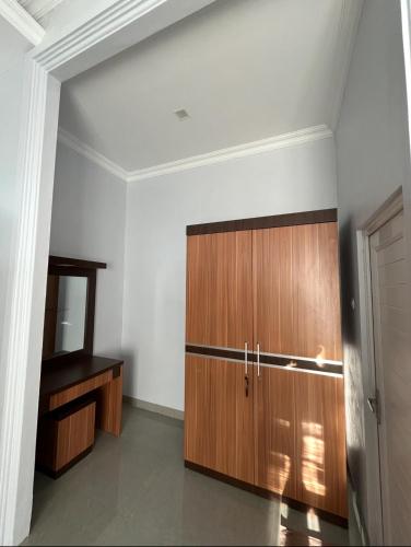 a room with a wooden cabinet and a mirror at Bukit Mega Raya in Geruntang