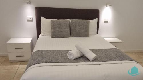 a bedroom with a large bed with two towels on it at Pelican Escape Executive Home in Cams Wharf