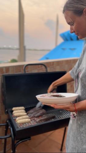 a woman holding a plate of food on a grill at Nalahost 2BR Seaview Terrace apartment in Male City