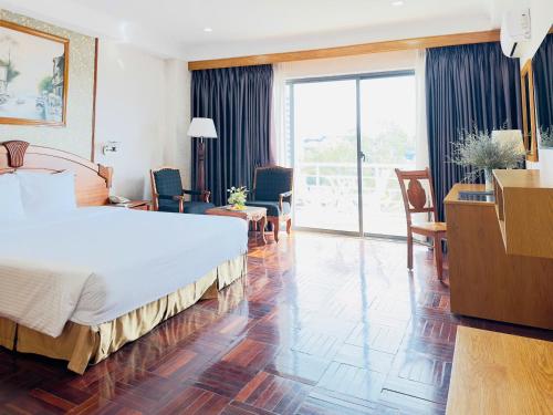 a hotel room with a large bed and a large window at Khách Sạn Mường Thanh Grand Gia Lai in Pleiku