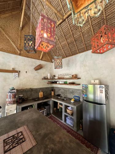 a kitchen with a stainless steel refrigerator and a table at Tipsea Turtle Gili Air in Gili Air
