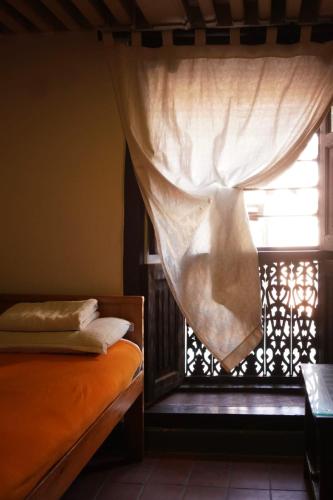 a bedroom with a window with a curtain at Hiranya Guest House in Pātan