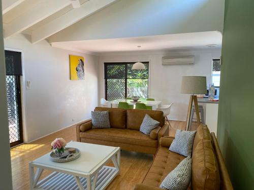 a living room with a couch and a table at Frangipani in Shoal Bay