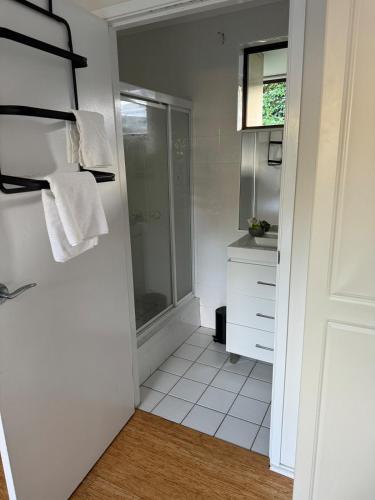 a bathroom with a shower and a sink with towels at Frangipani in Shoal Bay