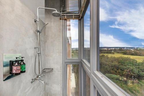 a bathroom with a shower and a window with a view at Kenting Fu Bao Inn in Hengchun