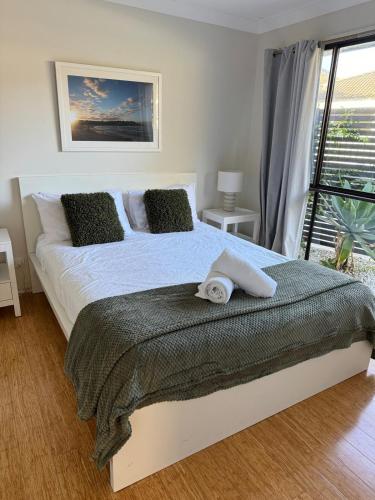 a bedroom with a bed with a towel on it at Frangipani in Shoal Bay