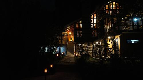 a building at night with lights in the dark at Into The Wild Manali in Vashisht
