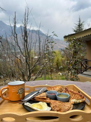 a tray with a plate of food on a table at Into The Wild Manali in Vashisht