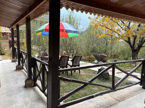 a colorful umbrella sitting on a porch at Into The Wild Manali in Vashisht