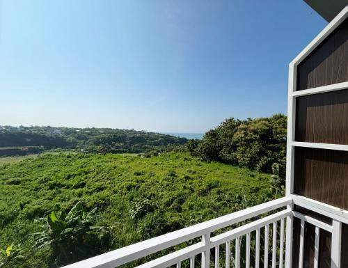 a balcony with a view of a green field at The Pandan Sari Hotel in Jimbaran