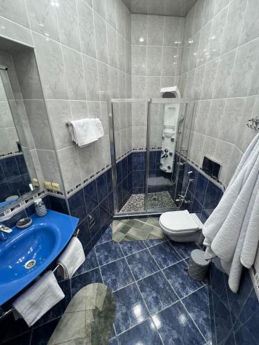 a bathroom with a blue sink and a toilet at Cozy apartment in the heart of Baku in Baku