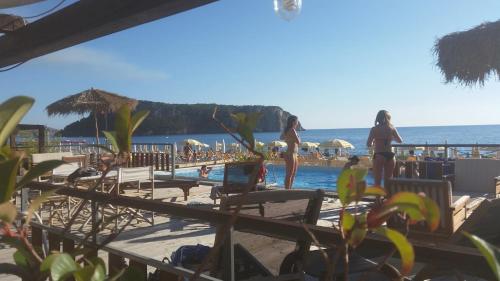 a group of people standing on a beach near the water at Max Guest House in Praia a Mare