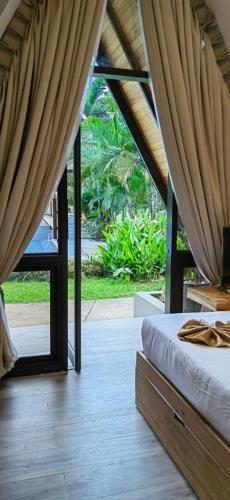 a bedroom with a bed and a large window at The Zen Villas Resort in Lipa