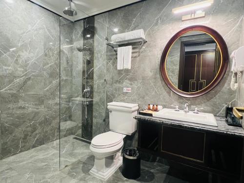 a bathroom with a toilet and a sink and a mirror at Hotel du Monde Art in Hanoi