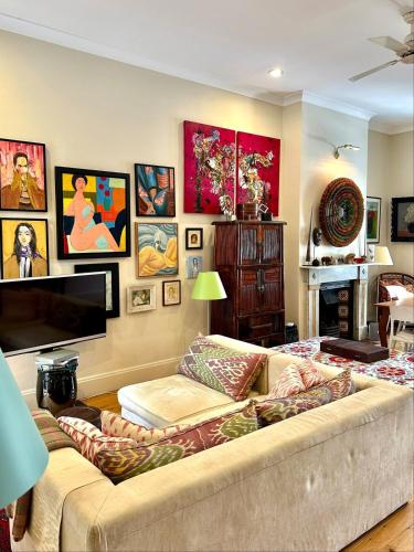 a living room with a couch and a flat screen tv at Art-Filled Designer Terrace in Chic Woollahra in Sydney
