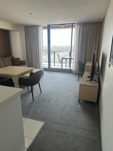 a hotel room with a living and dining area with a balcony at North Terrace Horizons free parking in Adelaide