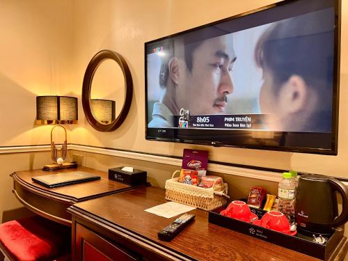 a flat screen tv sitting on a wall with a desk at Hotel du Monde Art in Hanoi