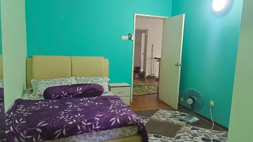 a bedroom with a bed and a blue wall at Layyin's Damai Residences in Shah Alam