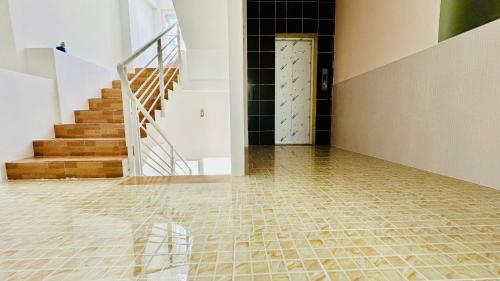a hallway with a staircase and a tiled floor at Yen Minh Resthouse in Ho Chi Minh City