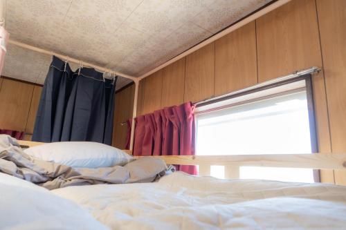 a bed sitting in a room with a window at 木の家ゲストハウス前橋2号館 in Maebashi