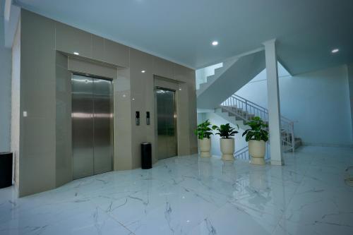 a hallway with three potted plants in a building at The Pandan Sari Hotel in Jimbaran