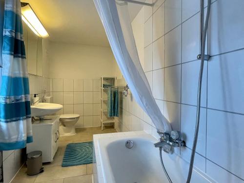 a bathroom with a tub and a toilet and a sink at 2 separate Appartements mit 5 Schlafzimmern für 9 Personen in Ühlingen-Birkendorf