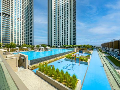 an overhead view of a large swimming pool with tall buildings at Blissful Stays - Luxury Two Bedroom Apartment at Downtown Views II- 5 min walk to Dubai Mall, Burj Khalifa with Infinity Pool in Dubai
