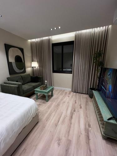 a bedroom with a bed and a couch and a table at استديو أنيق كلاسيكي in Riyadh