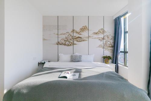 a bedroom with a bed and a window at Qingdao Shanhaiji Sea View B&B Wusi Square Branch in Fushansuo