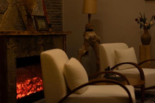 a living room with two chairs and a fireplace at One Zen Lodge Snowy Haven in Lijiang