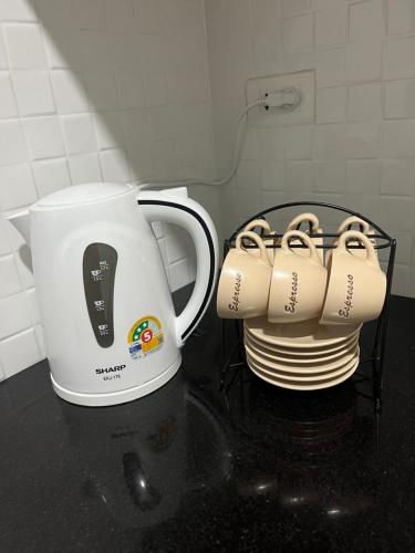 two coffee cups sitting next to a white mug at Lub Sabai in Yala