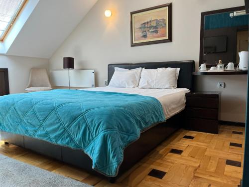 a bedroom with a large bed with a blue blanket at Pleasure Čair apartments in Niš