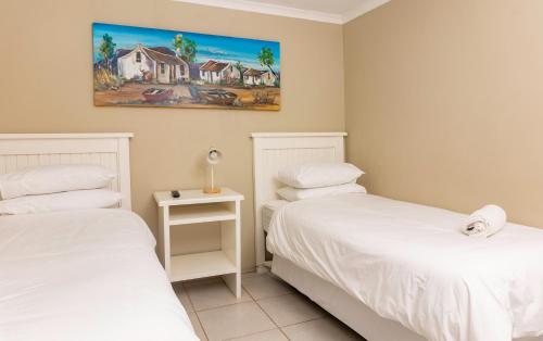a bedroom with two beds and a painting on the wall at Amberdale Estate Budget Self Catering in Queenstown