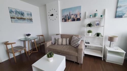 a living room with a couch and a table at Downtown Hua Hin Condo with Pool in Hua Hin