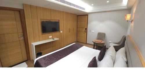 a hotel room with a bed and a television at Hotel Alwar Royals in Alwar