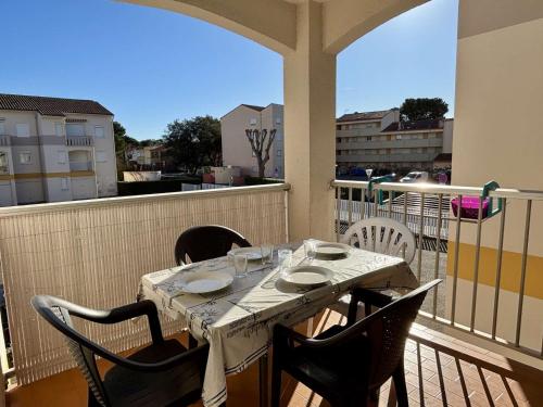 - une table sur un balcon avec une table et des chaises dans l'établissement Appartement cosy 2 pièces avec cabine, proche mer à Argelès, terrasse, parking, animaux admis - FR-1-225-723, à Argelès-sur-Mer