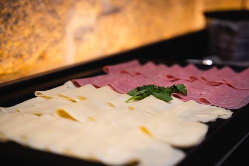 a plate of cheese with a parsley on top of it at The Central House Porto Ribeira in Porto