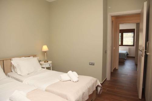 a hotel room with two beds and a hallway at Amorelia Casa in Lefkogeia