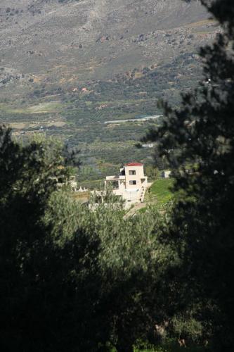a house on top of a hill with a mountain at Amorelia Casa in Lefkogeia