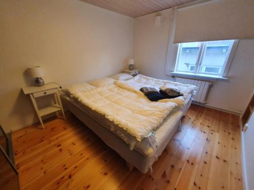 a bedroom with a bed and a wooden floor at 2 rum och kök varav 1 sovrum samt en stuga i anslutning med 1 sovrum in Oskarshamn