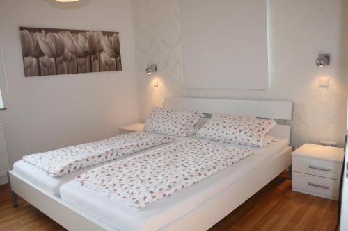 ein weißes Bett mit zwei Kissen im Schlafzimmer in der Unterkunft Ferienwohnungen Julia Volkach in Volkach